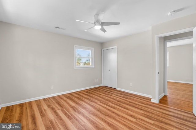 unfurnished bedroom featuring visible vents, baseboards, light wood-type flooring, a closet, and a ceiling fan