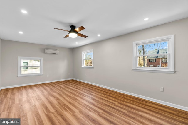 unfurnished room featuring recessed lighting, an AC wall unit, and baseboards