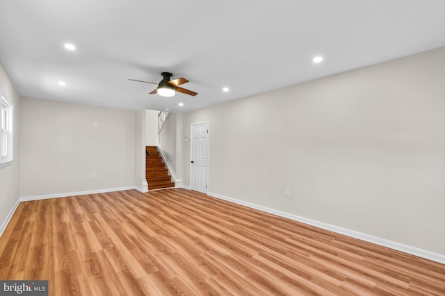 empty room with stairway, a ceiling fan, baseboards, recessed lighting, and light wood-style floors