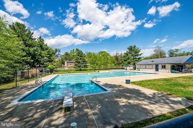 pool with a patio area, a lawn, and fence