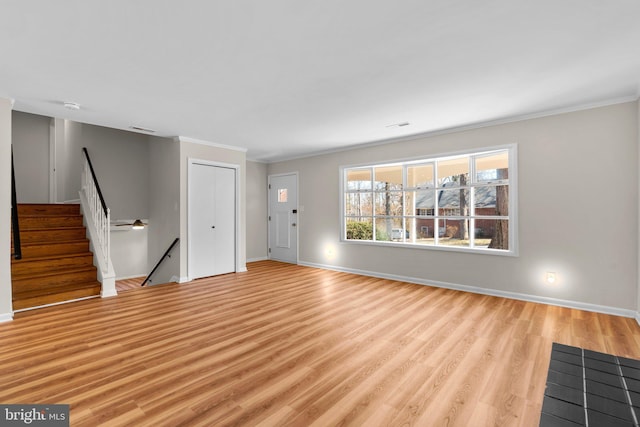 unfurnished living room featuring light wood finished floors, baseboards, and ornamental molding