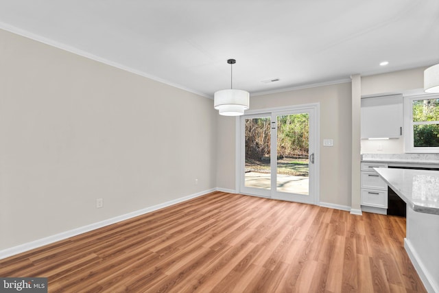 unfurnished dining area featuring visible vents, light wood-style flooring, recessed lighting, crown molding, and baseboards