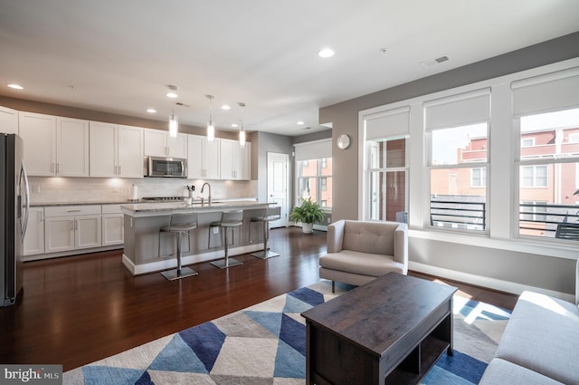 living room featuring recessed lighting, visible vents, baseboards, and dark wood-style floors