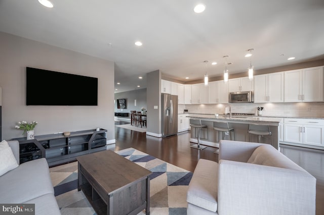 living room with dark wood-type flooring and recessed lighting