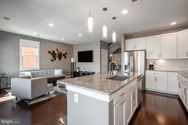 kitchen with visible vents, dark wood finished floors, a sink, appliances with stainless steel finishes, and open floor plan