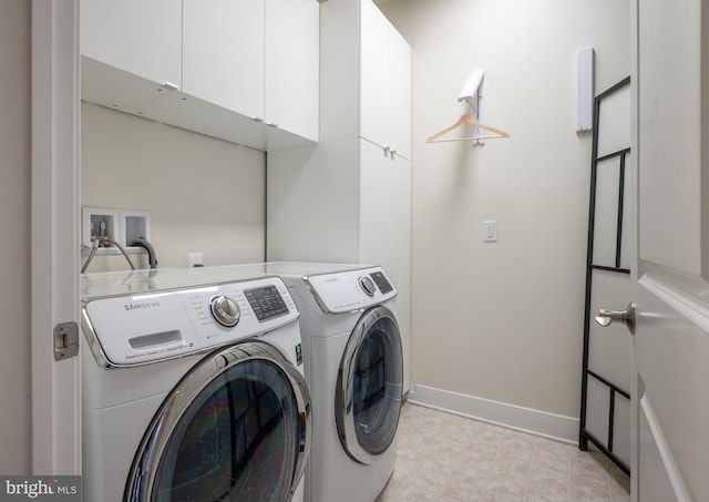 clothes washing area featuring baseboards, cabinet space, and washing machine and clothes dryer