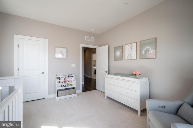 bedroom with washer / dryer, baseboards, visible vents, and light carpet