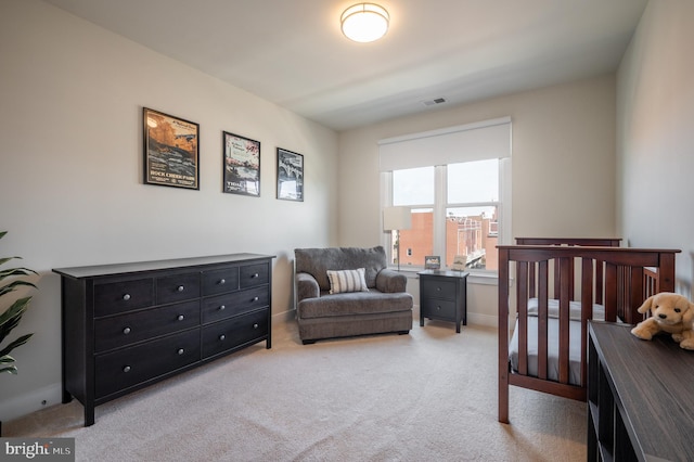 bedroom with visible vents, light carpet, and baseboards