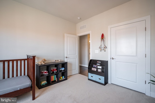 carpeted bedroom featuring visible vents