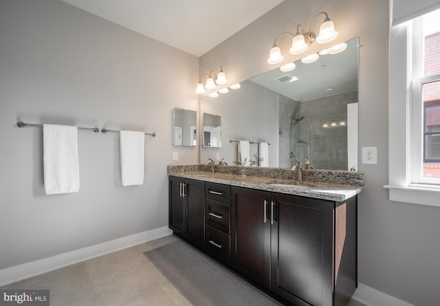 bathroom with a sink, baseboards, a stall shower, and tile patterned flooring