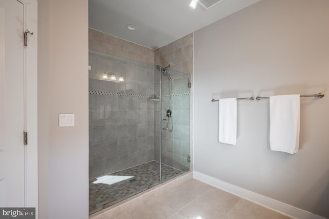 bathroom with tile patterned flooring, a shower stall, visible vents, and baseboards