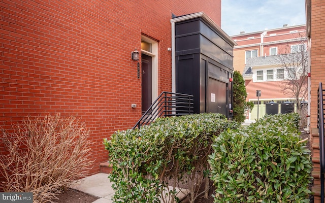 doorway to property featuring brick siding