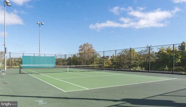 view of tennis court featuring fence