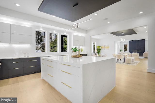 kitchen with light wood-style floors, modern cabinets, white cabinetry, and light countertops