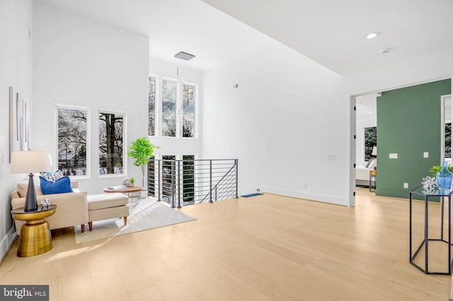 interior space with recessed lighting, an upstairs landing, a healthy amount of sunlight, baseboards, and light wood finished floors