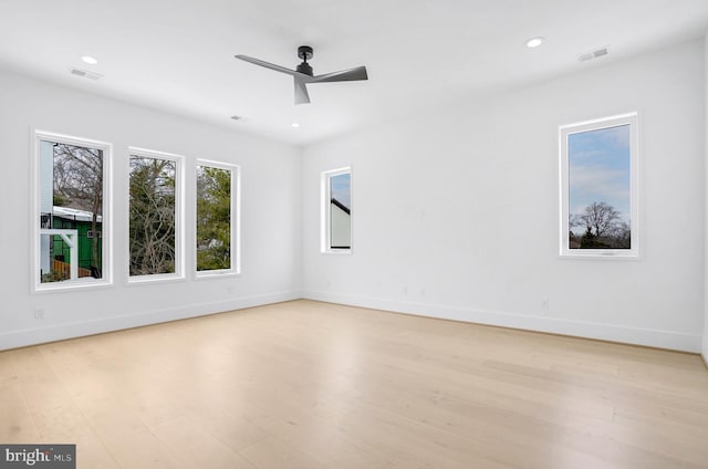 spare room featuring light wood-type flooring, baseboards, and visible vents