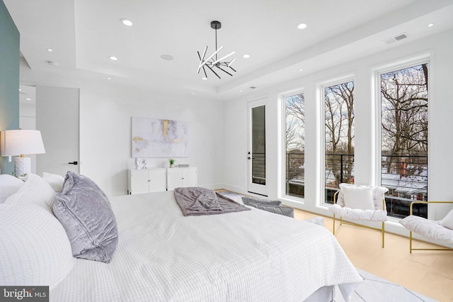 bedroom featuring a notable chandelier, recessed lighting, a raised ceiling, visible vents, and wood finished floors