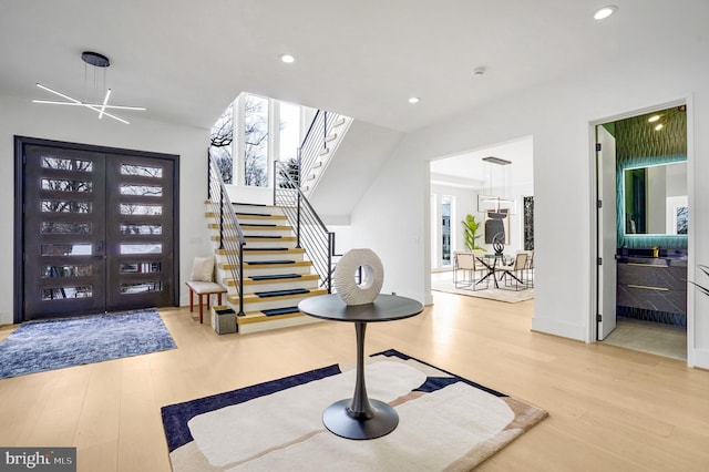 foyer entrance featuring recessed lighting, a healthy amount of sunlight, stairway, and wood finished floors