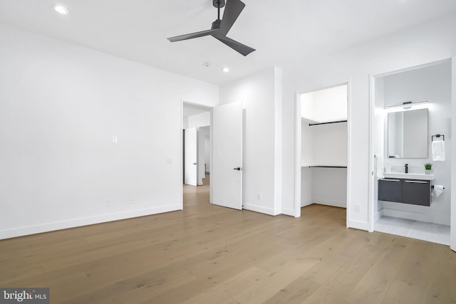 unfurnished bedroom with light wood-type flooring, baseboards, connected bathroom, and recessed lighting