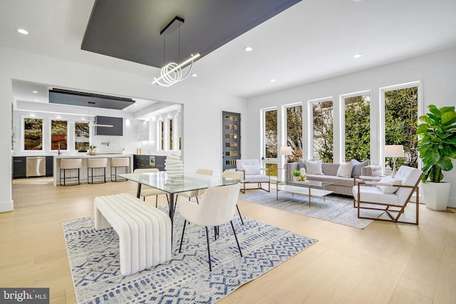 dining room featuring a chandelier, recessed lighting, and light wood-style floors