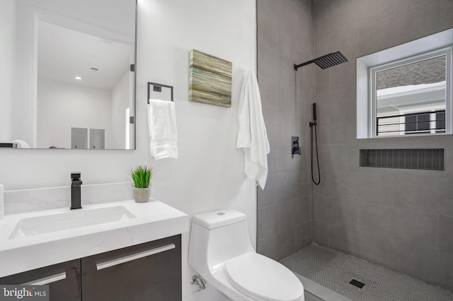 full bath with toilet, tiled shower, and vanity