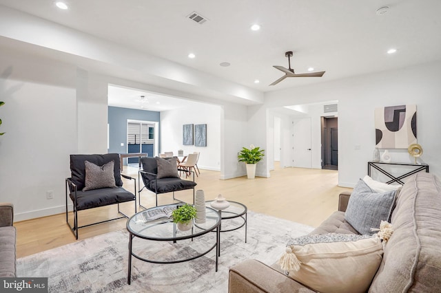 living room featuring light wood-type flooring, visible vents, and recessed lighting