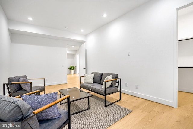 living room featuring light wood-style floors, baseboards, and recessed lighting