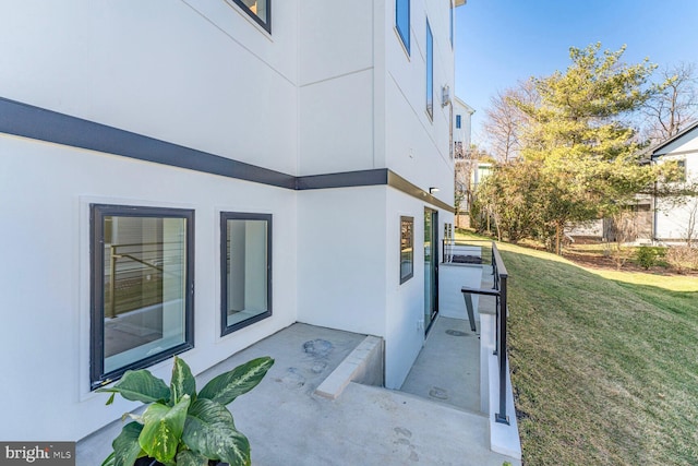 view of property exterior with a lawn and stucco siding