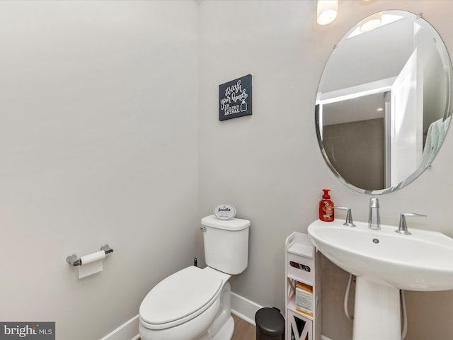 bathroom with baseboards, a sink, and toilet