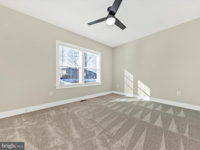 carpeted empty room featuring visible vents, baseboards, and ceiling fan