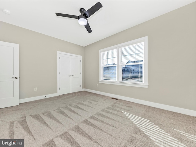 unfurnished bedroom with ceiling fan, carpet floors, visible vents, baseboards, and a closet