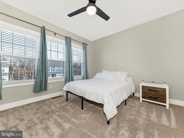 carpeted bedroom with ceiling fan, visible vents, and baseboards