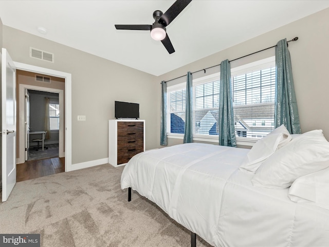 carpeted bedroom with baseboards, visible vents, and a ceiling fan