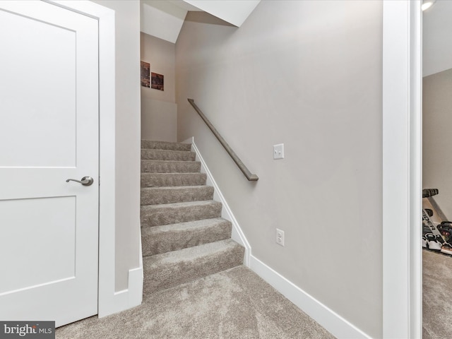 staircase featuring carpet and baseboards