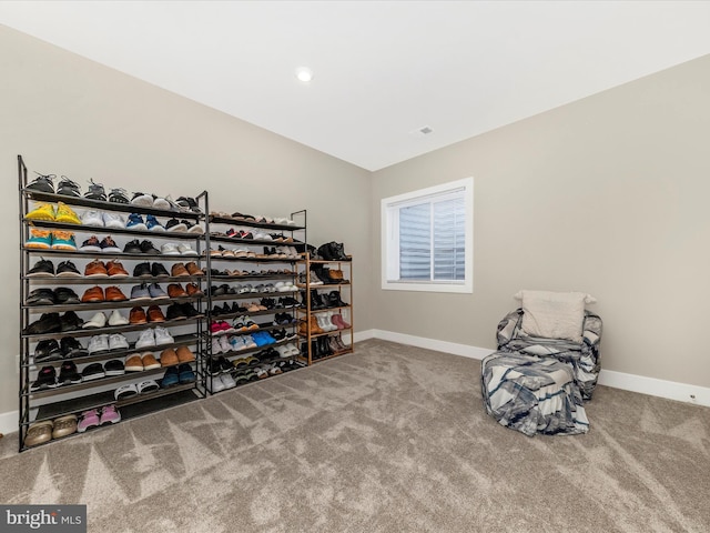 living area with vaulted ceiling, carpet floors, visible vents, and baseboards