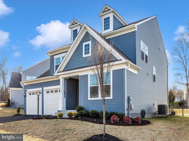 view of front of property with aphalt driveway, an attached garage, central AC unit, a front yard, and fence