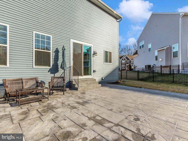 back of house featuring entry steps, a patio area, and fence