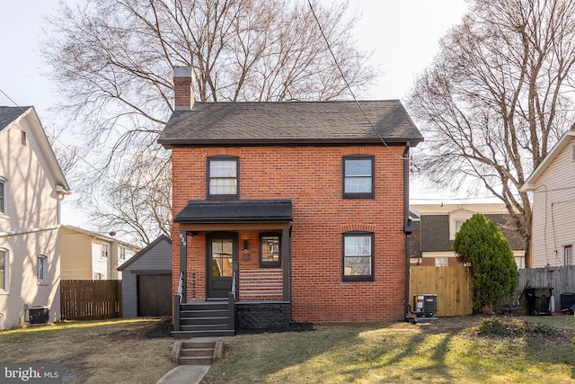 view of front of house featuring a chimney, fence, and brick siding