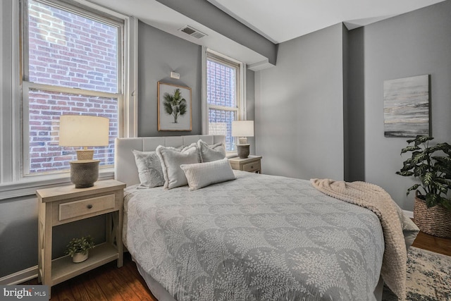 bedroom featuring visible vents and wood finished floors