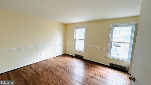 spare room featuring wood-type flooring and visible vents