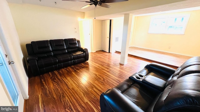 living area with a ceiling fan, visible vents, baseboards, and wood finished floors