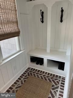 mudroom with brick floor and wainscoting