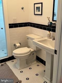 full bath featuring tile patterned flooring, tile walls, toilet, and walk in shower