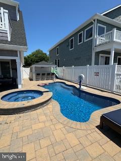 view of pool with a patio area, a fenced in pool, an in ground hot tub, and fence