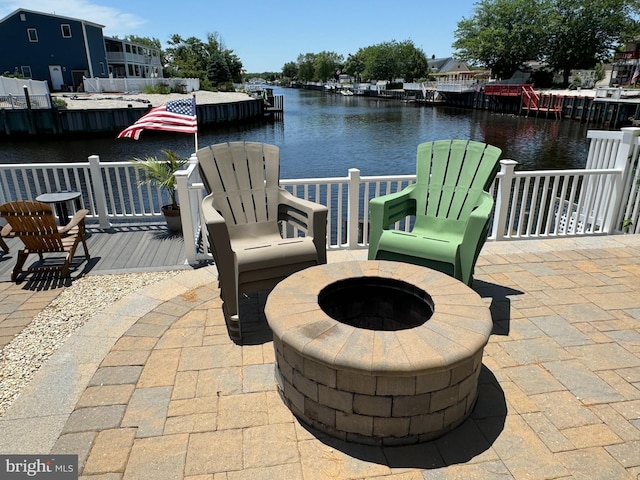 view of patio / terrace with a fire pit and a water view