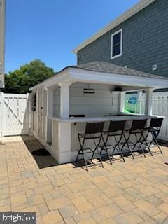 view of patio featuring fence and outdoor dry bar