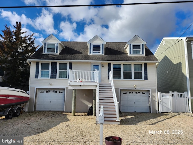 view of front of home with a garage, driveway, fence, and stairs