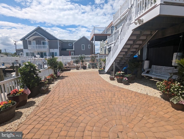 view of patio / terrace with a residential view, fence, and stairway