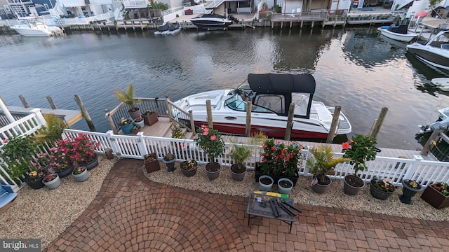 view of dock with a water view and fence