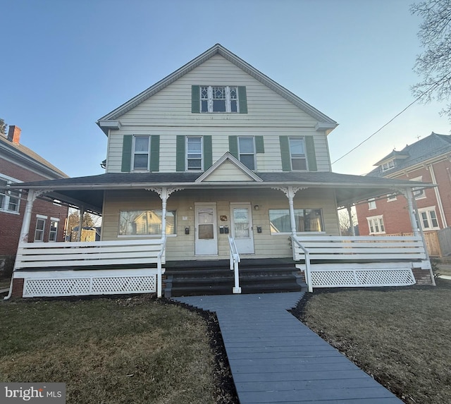 view of front of property with a porch and a front lawn